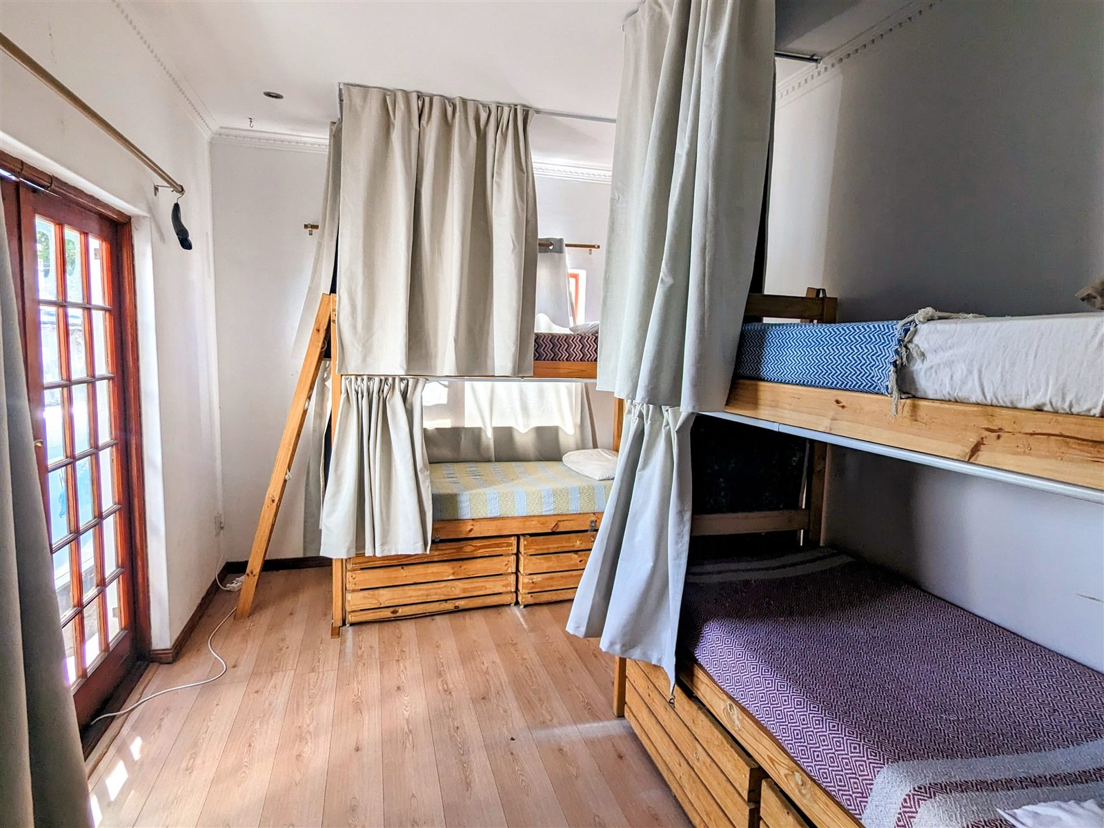A Khaya dorm room with curtained bunk beds