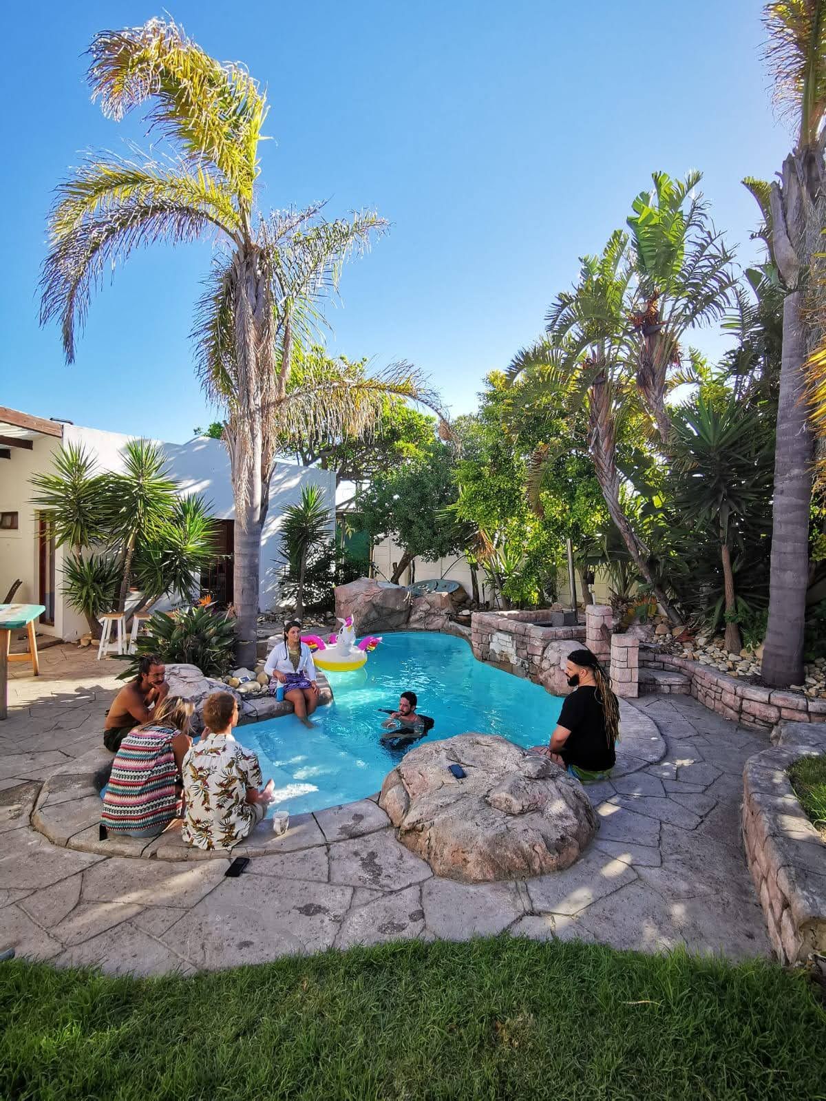 Guests chatting around the pool at Khaya on a sunny afternoon