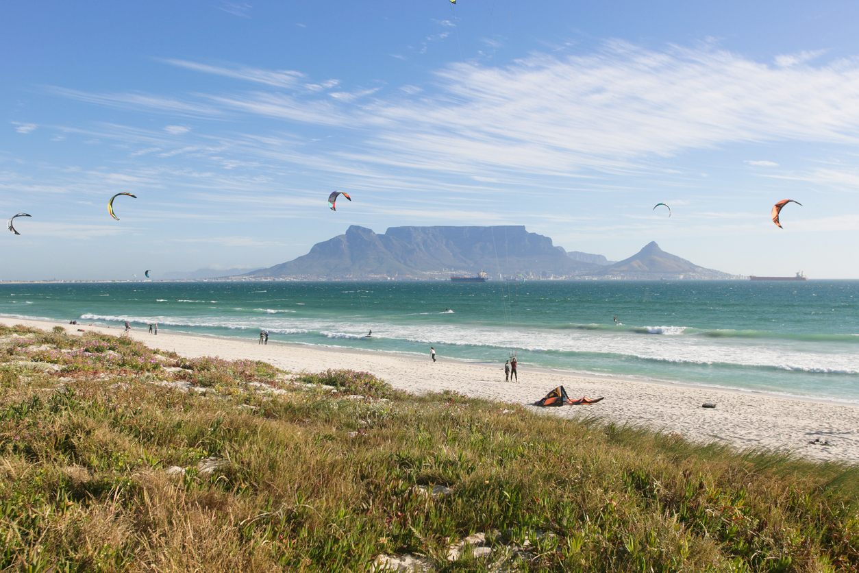 Kite Beach in Bloubergstrand, kites in the air and Table Mountain across the bay
